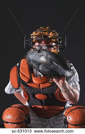 Stock Image - Baseball catcher holding ball in mitt. Fotosearch