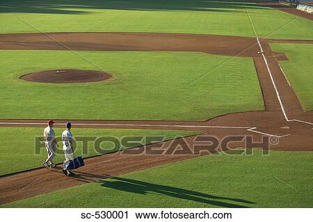 Stock Image - Baseball Players Walking in Field. Fotosearch