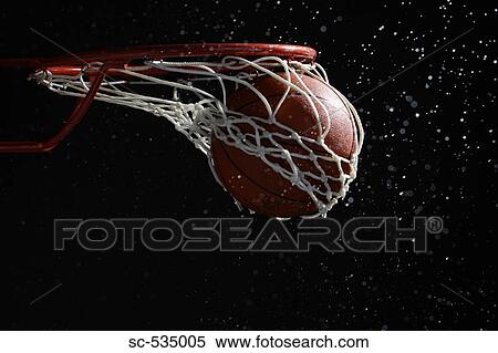 Stock Photography - Basketball going through hoop. Fotosearch