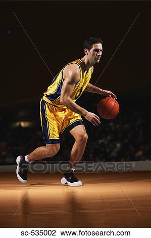 Stock Image - Basketball player dribbling ball . Fotosearch