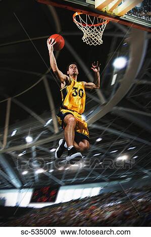 Stock Photo - Basketball player jumping in air. Fotosearch