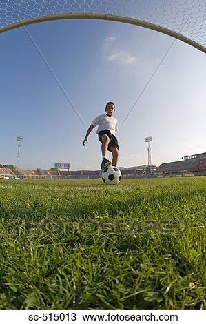 Stock Image - Boy approaching the goal. Fotosearch