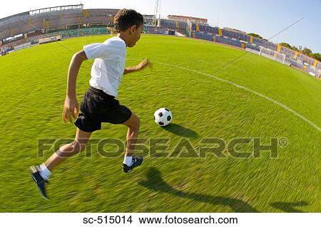 Picture - Boy dribbling a ball. Fotosearch