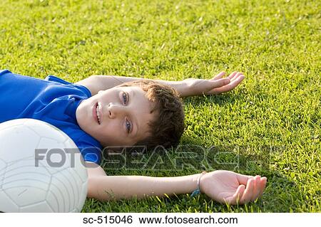Stock Photograph - Boy lying on grass. Fotosearch