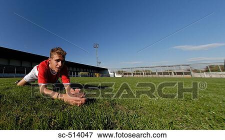 Stock Photo - Boy stretching on a pitch. Fotosearch