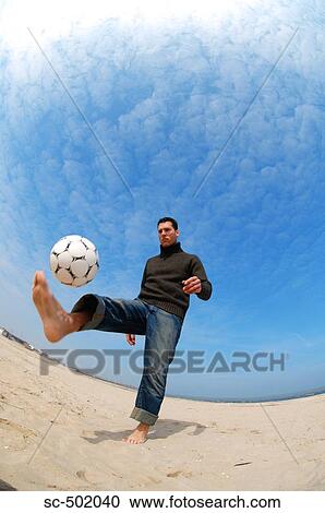 Caucasian male practicing soccer on beach View Large Photo Image Stock Image - Caucasian male practicing soccer on beach. Fotosearch