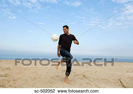 Caucasian male practicing soccer on beach View Large Photo Image Stock Image - Caucasian male practicing soccer on beach. Fotosearch