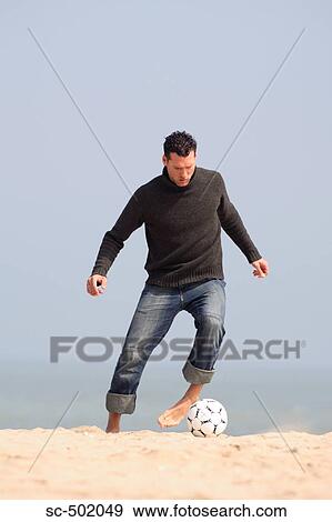 Caucasian male practicing soccer on beach View Large Photo Image Stock Photo - Caucasian male practicing soccer on beach. Fotosearch