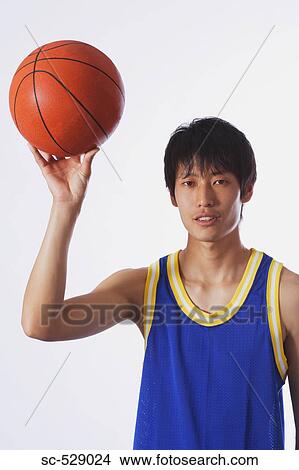 Picture - Chinese young man throwing basketball. Fotosearch
