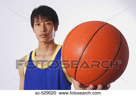 Stock Image - Chinese young man with basketball. Fotosearch