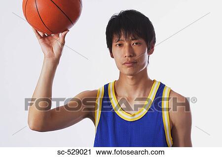 Stock Image - Chinese young man with basketball. Fotosearch