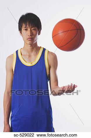 Stock Image - Chinese young man with basketball. Fotosearch