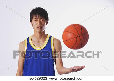 Stock Image - Chinese young man with basketball. Fotosearch