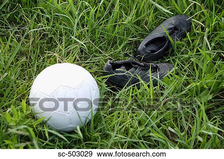Stock Photo - Cleats And Soccer Ball Lying In a Field. Fotosearch