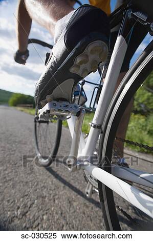 Stock Photography - Close-up of a cyclist cycling on road. Fotosearch