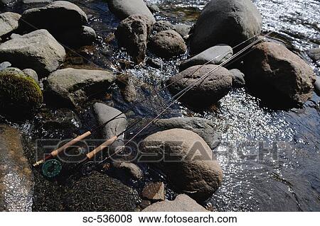 Fishing rod and reel on water View Large Photo Image Stock Photo - Fishing rod and reel on water. Fotosearch