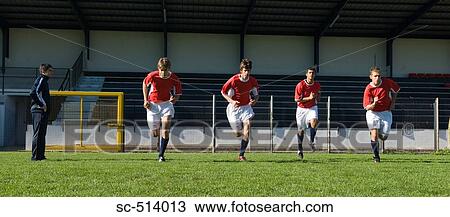 Stock Image - Four soccer players sprinting. Fotosearch