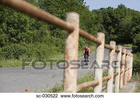 Front view of a man cycling on road View Large Photo Image Stock Image - Front view of a man cycling on road. Fotosearch