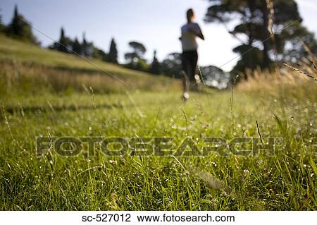 Stock Image - Girl jogging in countryside. Fotosearch