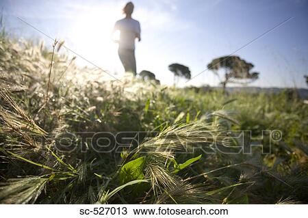 Stock Image - Girl jogging in countryside. Fotosearch