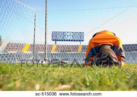 Stock Photograph - Goal keeper broken down in guilt. Fotosearch