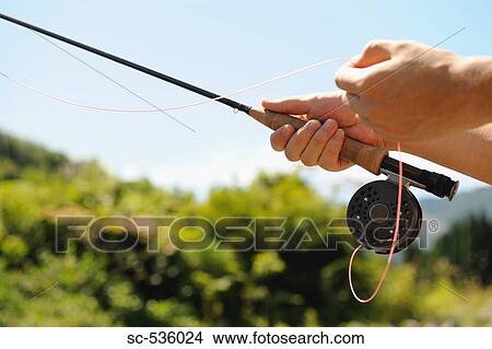 Picture - Hands holding fishing rod and reel. Fotosearch