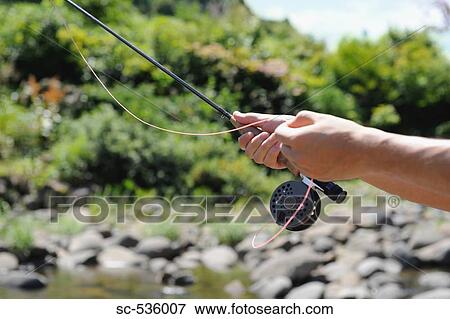 Hands holding fishing rod View Large Photo Image Stock Photo - Hands holding fishing rod. Fotosearch