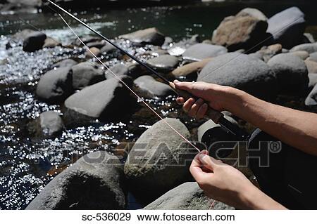 Stock Photo - Hands holding fishing rod. Fotosearch