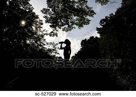Stock Photo - Jogger relaxing and drinking water. Fotosearch