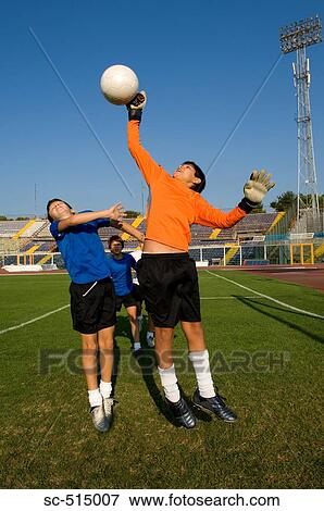 Stock Photo - Keeper punching the ball away. Fotosearch