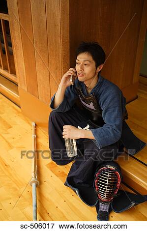 Stock Photo - Kendo Fencer Talking On Mobile Phone. Fotosearch