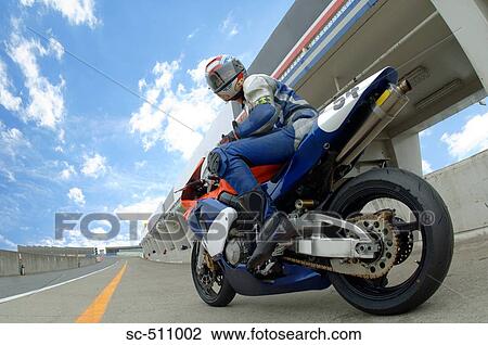 Stock Image - Low Angle View of Motorcycle Racer. Fotosearch