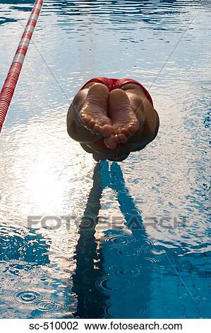 Stock Image - Male swimmer diving into pool. Fotosearch