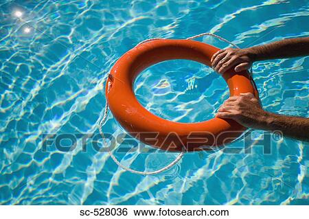 Stock Photograph - Man holding life ring floating in water. Fotosearch