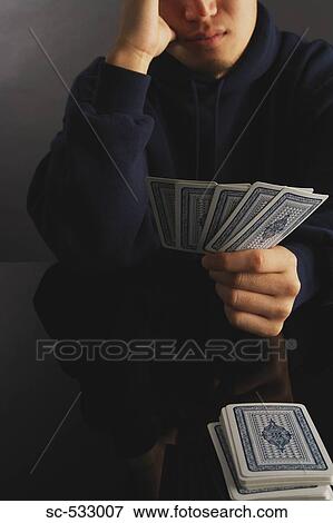 Man holding playing cards in his hands View Large Photo Image Stock Photo - Man holding playing cards in his hands. Fotosearch