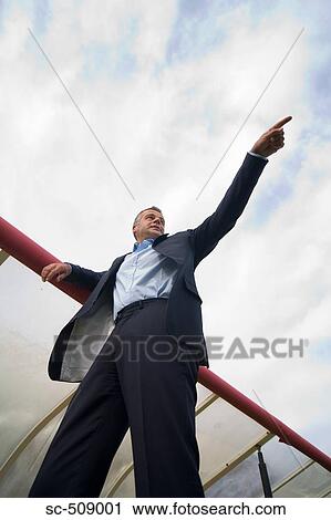 Stock Image - Man in suit pointing. Fotosearch