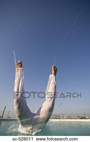 Stock Image - Man jumping into swimming pool. Fotosearch