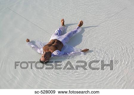 Man lying on the beach View Large Photo Image Stock Photo - Man lying on the beach. Fotosearch