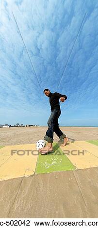 Stock Image - Man Playing Soccer On Beach. Fotosearch