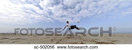 Stock Photograph - Man Playing Soccer On Beach. Fotosearch