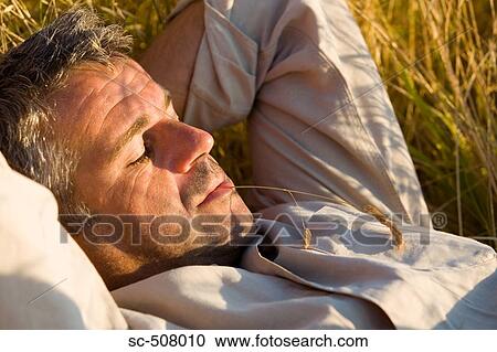 Man relaxing in long grass View Large Photo Image Stock Image - Man relaxing in long grass. Fotosearch