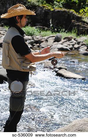 Stock Photo - Man with straw hat and holding fishing rod. Fotosearch