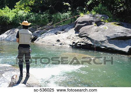 Man with straw hat standing on stone and fishing View Large Photo Image Stock Photography - Man with straw hat standing on stone and fishing. Fotosearch