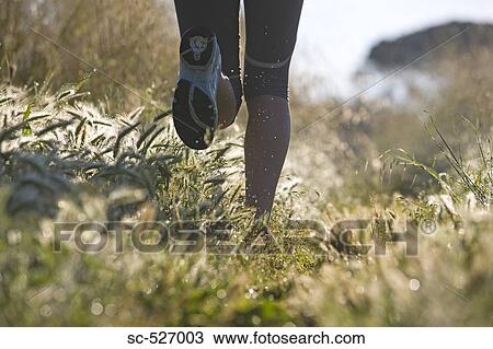 Stock Image - Person jogging in countryside. Fotosearch