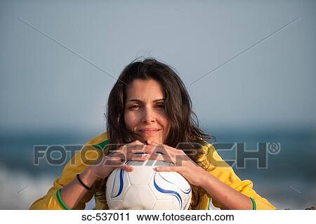 Stock Image - Player posing with soccer ball. Fotosearch