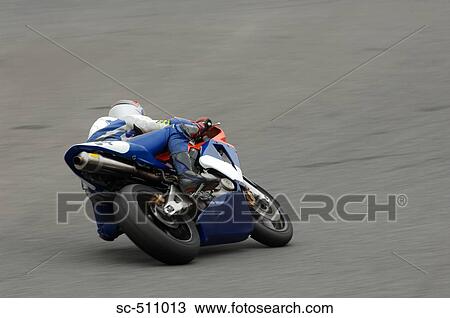 Stock Image - Racing motor bike cornering at speed. Fotosearch