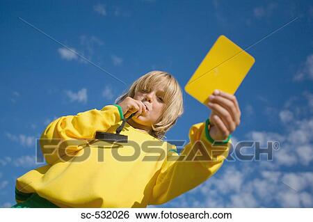 Stock Photograph - Referee blowing whistle and showing yellow card. Fotosearch