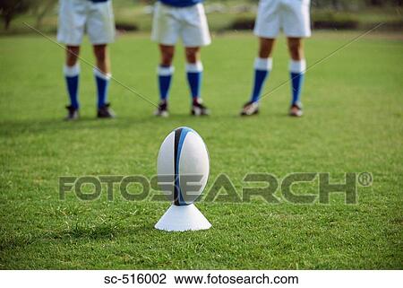 Rugby Ball On A Tee With Kickers In The Background View Large Photo Image Stock Image - Rugby Ball On A Tee With Kickers In The Background. Fotosearch
