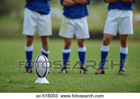 Rugby Ball On A Tee With Kickers In The Background View Large Photo Image Stock Image - Rugby Ball On A Tee With Kickers In The Background. Fotosearch