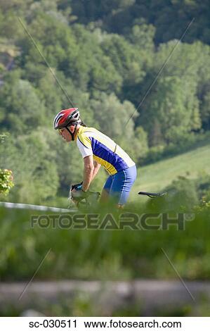 Side view of a man cycling View Large Photo Image Stock Image - Side view of a man cycling. Fotosearch